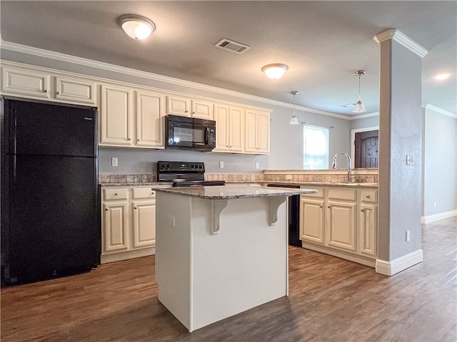 kitchen with decorative light fixtures, dark hardwood / wood-style flooring, black appliances, crown molding, and a center island