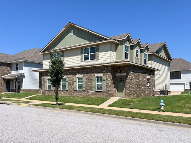 view of front of home featuring central AC, brick siding, board and batten siding, and a front yard