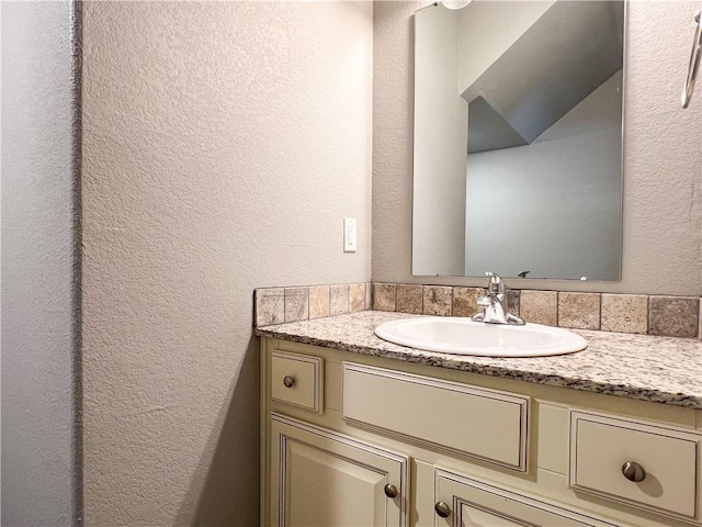 bathroom with a textured wall and vanity