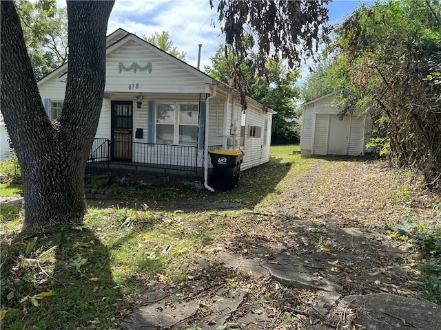 view of front of house featuring a storage shed and covered porch