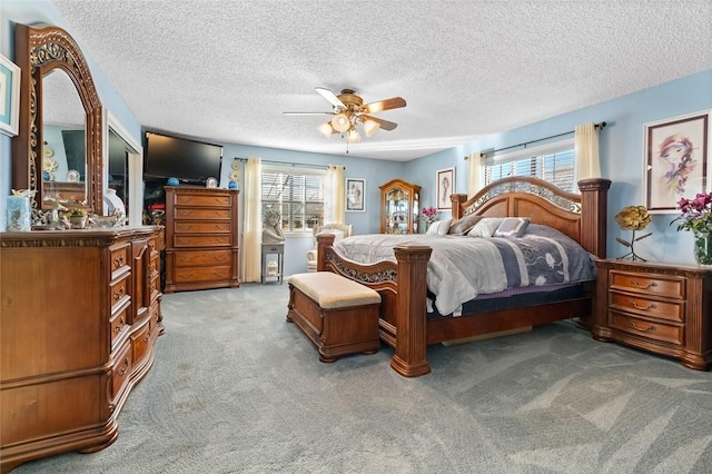 bedroom with carpet floors, ceiling fan, and a textured ceiling