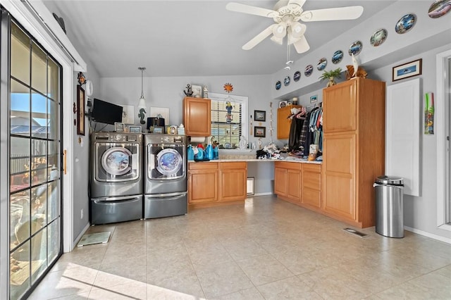 interior space featuring cabinet space, light tile patterned floors, visible vents, washer and clothes dryer, and a ceiling fan