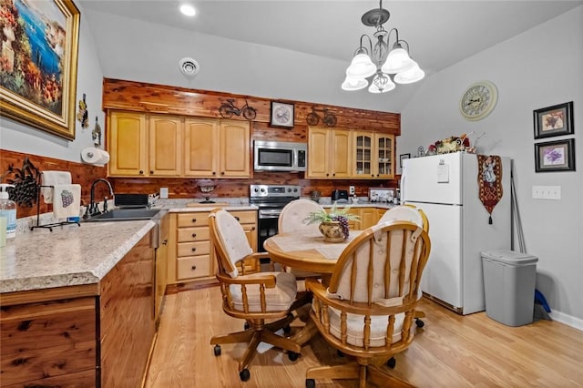 kitchen with lofted ceiling, light wood-style flooring, visible vents, light countertops, and appliances with stainless steel finishes