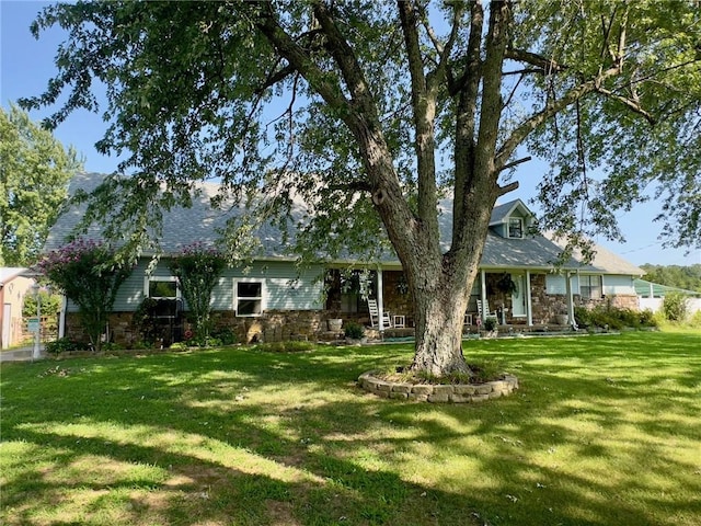 view of front of home with stone siding and a front lawn