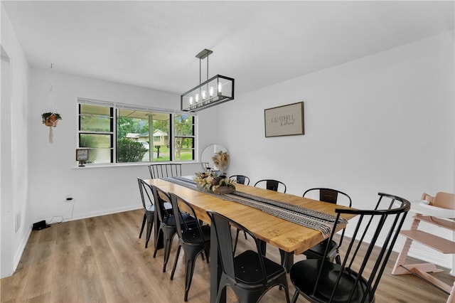 dining space featuring an inviting chandelier and light hardwood / wood-style flooring