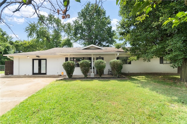 ranch-style home featuring french doors and a front yard