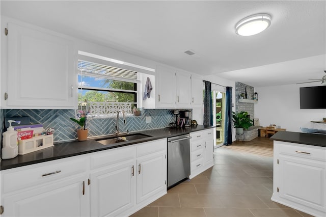 kitchen featuring dishwasher, sink, decorative backsplash, ceiling fan, and white cabinets