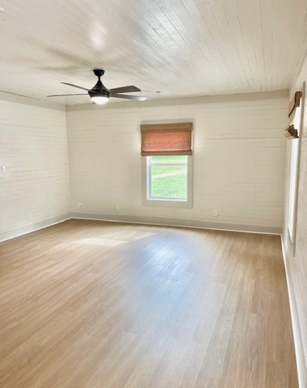 spare room featuring a ceiling fan, baseboards, and wood finished floors