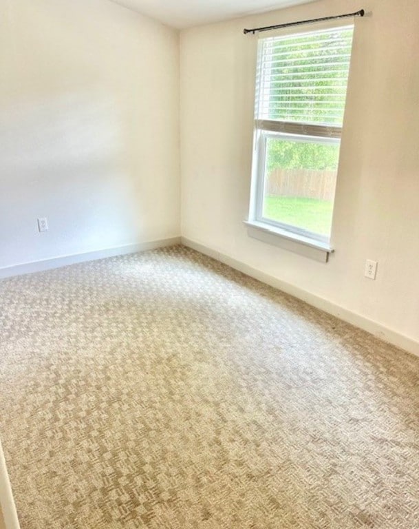 carpeted empty room with baseboards