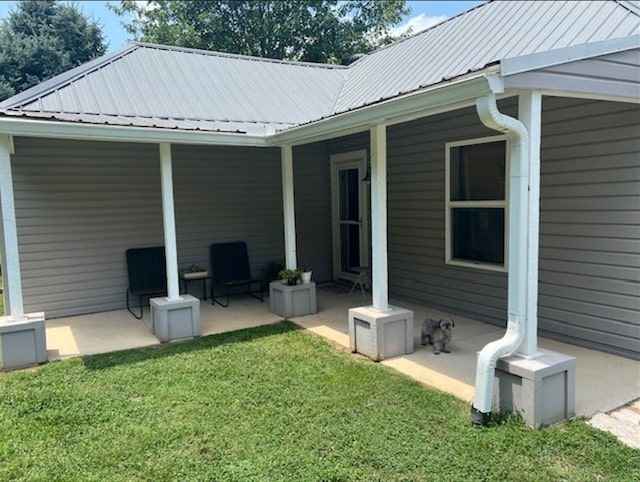 exterior space featuring a patio area, metal roof, and a yard