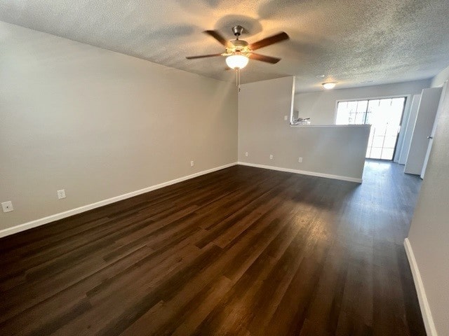 spare room with a textured ceiling, ceiling fan, and dark hardwood / wood-style floors