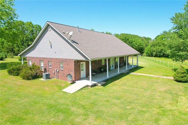 back of house featuring a lawn, a patio area, and central AC