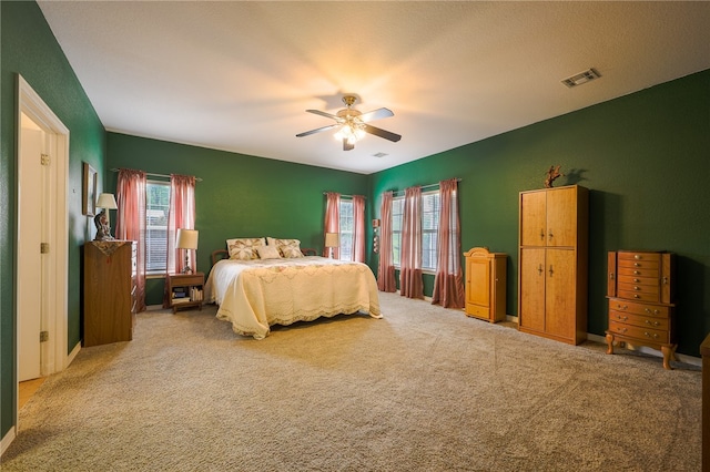 carpeted bedroom with a textured ceiling and ceiling fan