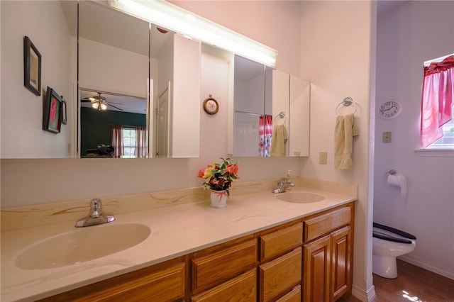 bathroom with ceiling fan, toilet, wood-type flooring, and vanity