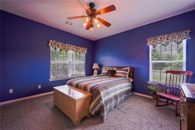 carpeted bedroom with ceiling fan and multiple windows