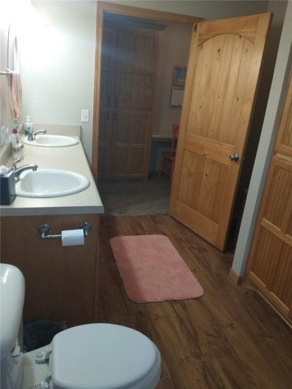 bathroom with vanity, toilet, and hardwood / wood-style floors