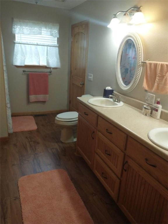 bathroom featuring toilet, hardwood / wood-style flooring, and vanity