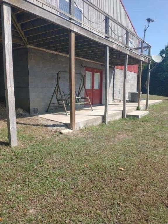 exterior space featuring cooling unit, a lawn, and a patio area