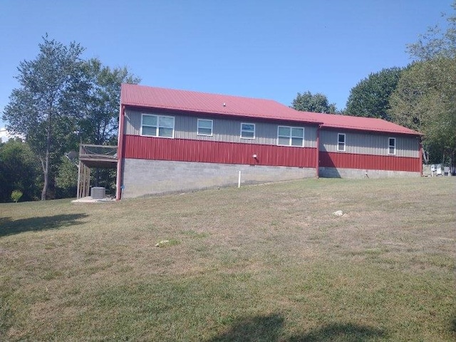 back of house featuring a lawn and central AC