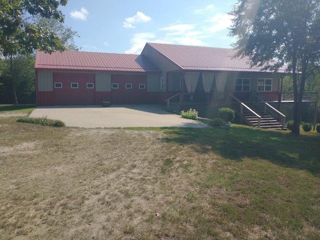 rear view of property with a garage and a yard