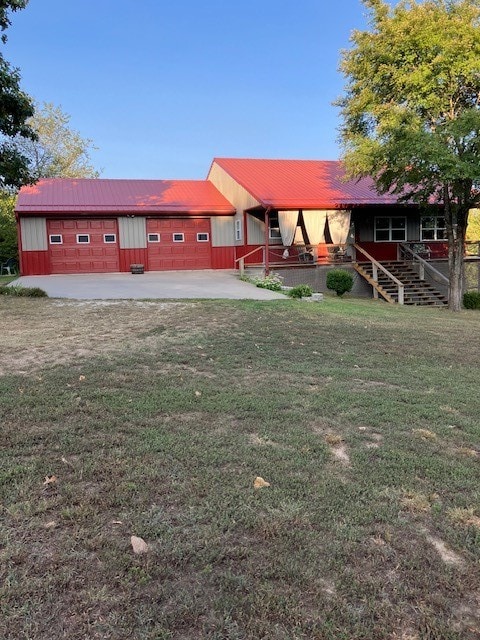 view of yard featuring covered porch and a garage