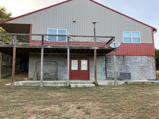 back of house featuring a wooden deck, a lawn, and central AC unit