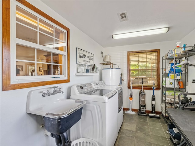 washroom with washing machine and clothes dryer, water heater, a textured ceiling, and sink