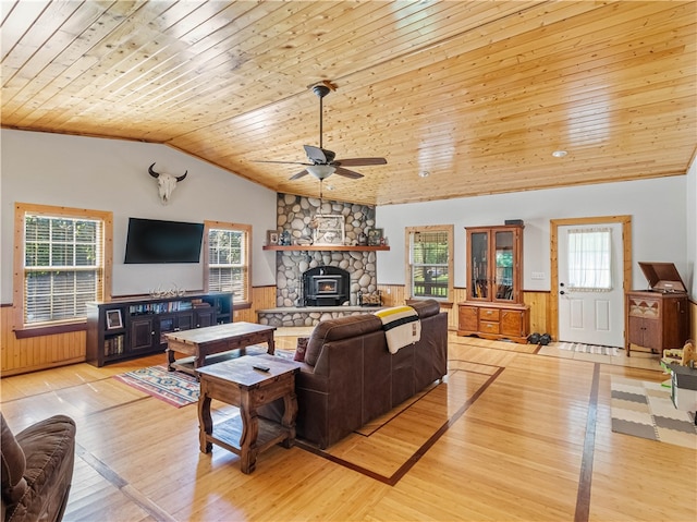 living room featuring light wood-type flooring, wood walls, vaulted ceiling, ceiling fan, and wooden ceiling