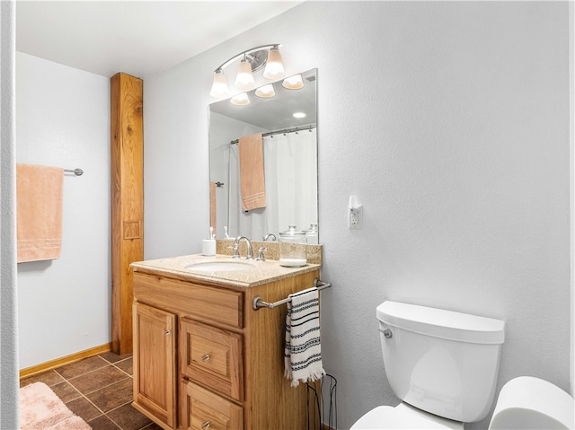 bathroom with tile patterned flooring, vanity, and toilet