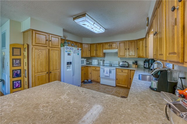 kitchen featuring a textured ceiling, sink, and white appliances