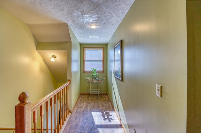 hallway with wood-type flooring and a textured ceiling