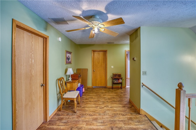 hallway with hardwood / wood-style flooring and a textured ceiling