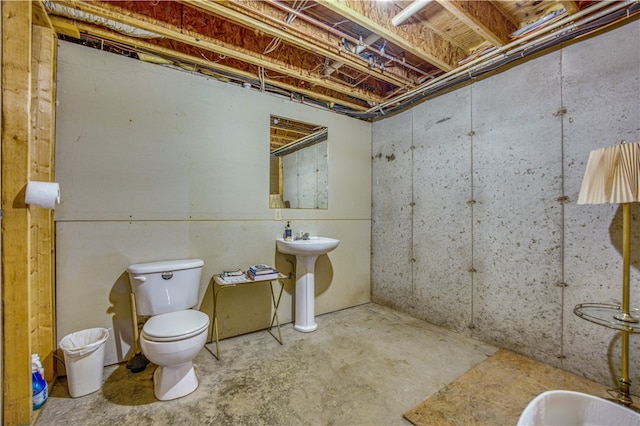 bathroom featuring concrete floors, sink, and toilet