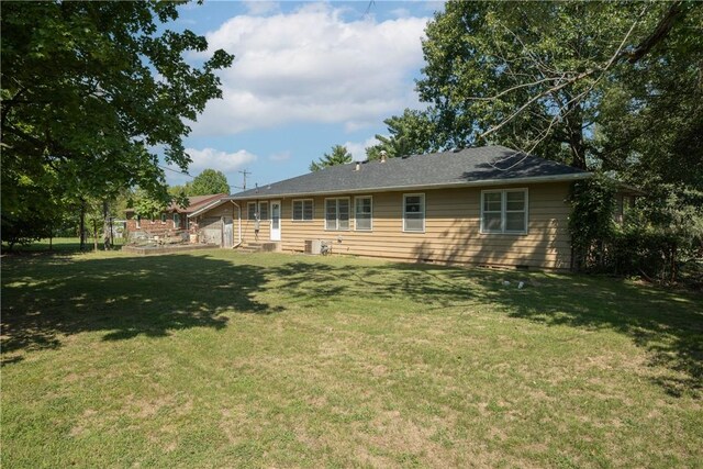 rear view of property featuring a yard