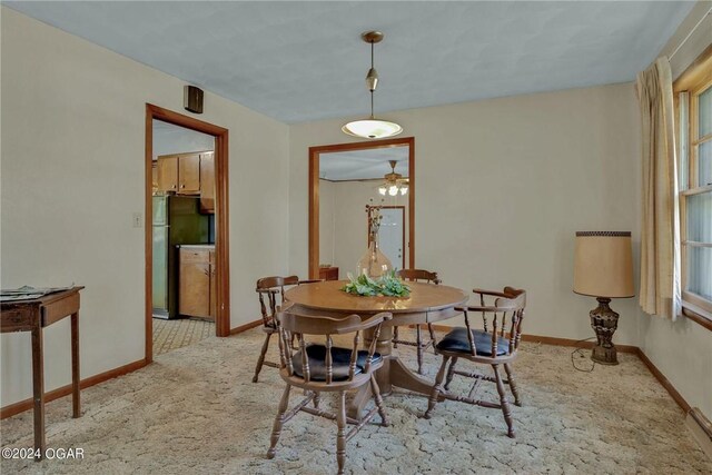 carpeted dining space featuring ceiling fan