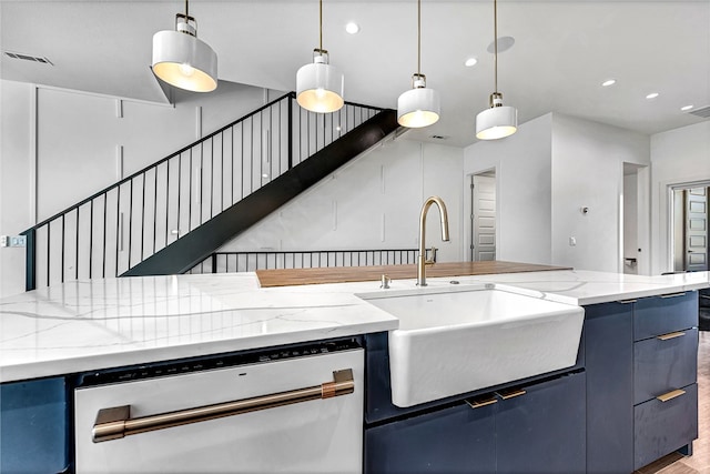 kitchen featuring dishwasher, light stone counters, sink, and hardwood / wood-style floors