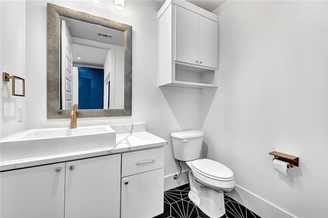 bathroom with vanity, toilet, and tile patterned floors