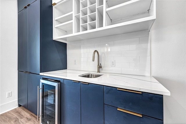 kitchen with hardwood / wood-style floors, wine cooler, sink, and blue cabinetry