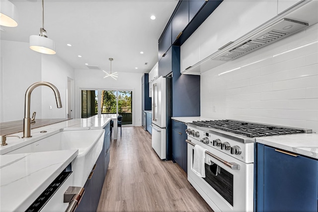 kitchen with light wood-type flooring, pendant lighting, light stone counters, and high quality appliances