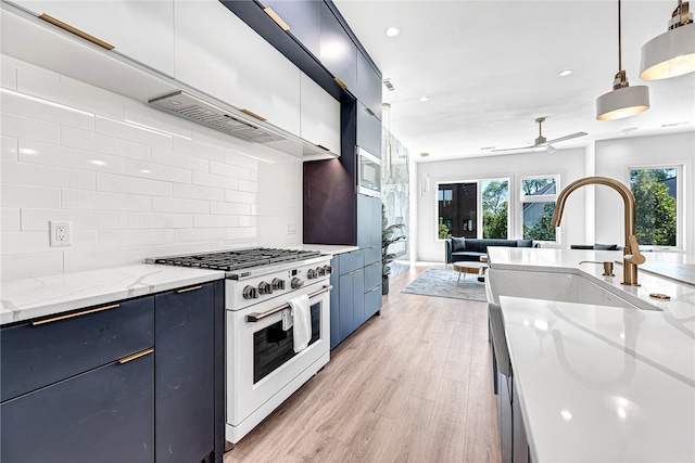 kitchen featuring light wood-type flooring, pendant lighting, range with two ovens, light stone countertops, and ceiling fan