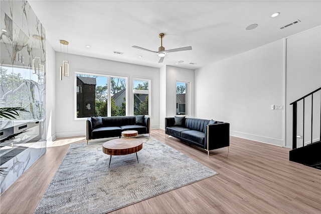 living room with ceiling fan and light hardwood / wood-style floors