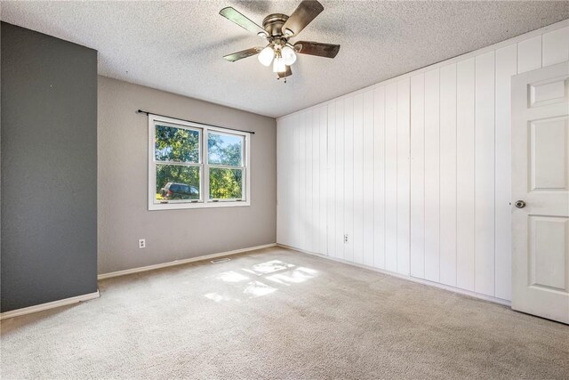 carpeted spare room featuring a textured ceiling and ceiling fan