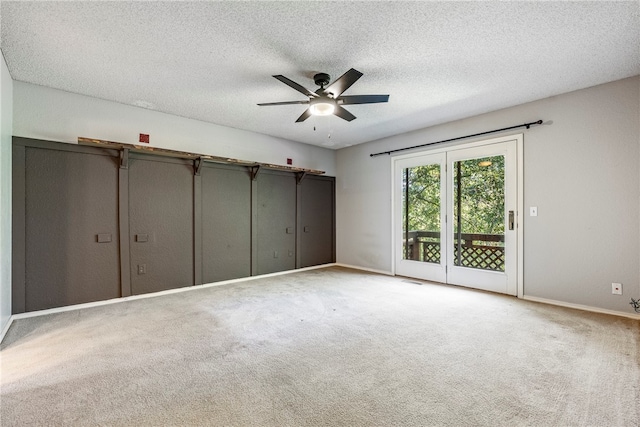 unfurnished bedroom with carpet flooring, ceiling fan, access to outside, and a textured ceiling