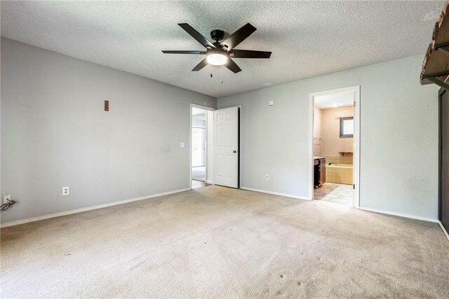 unfurnished bedroom featuring light colored carpet, connected bathroom, ceiling fan, and a textured ceiling