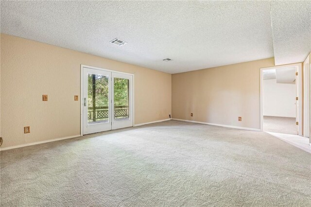 carpeted spare room with a textured ceiling