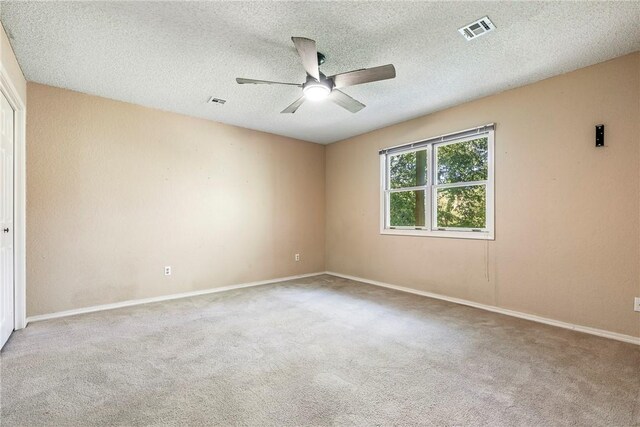 carpeted empty room featuring ceiling fan and a textured ceiling