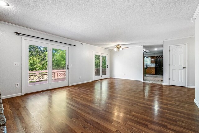 unfurnished living room featuring a textured ceiling, a healthy amount of sunlight, ceiling fan, and wood-type flooring