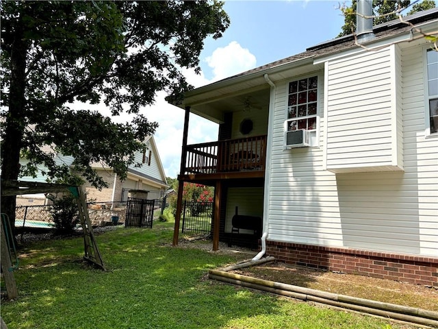 exterior space with ceiling fan, fence, and a yard