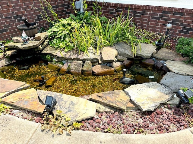 exterior details with a small pond and brick siding