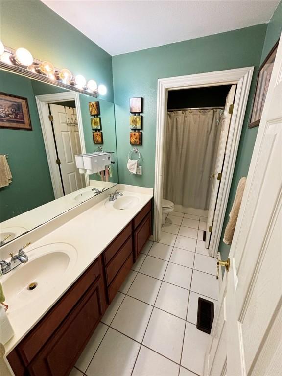 full bathroom featuring a sink, toilet, and tile patterned floors